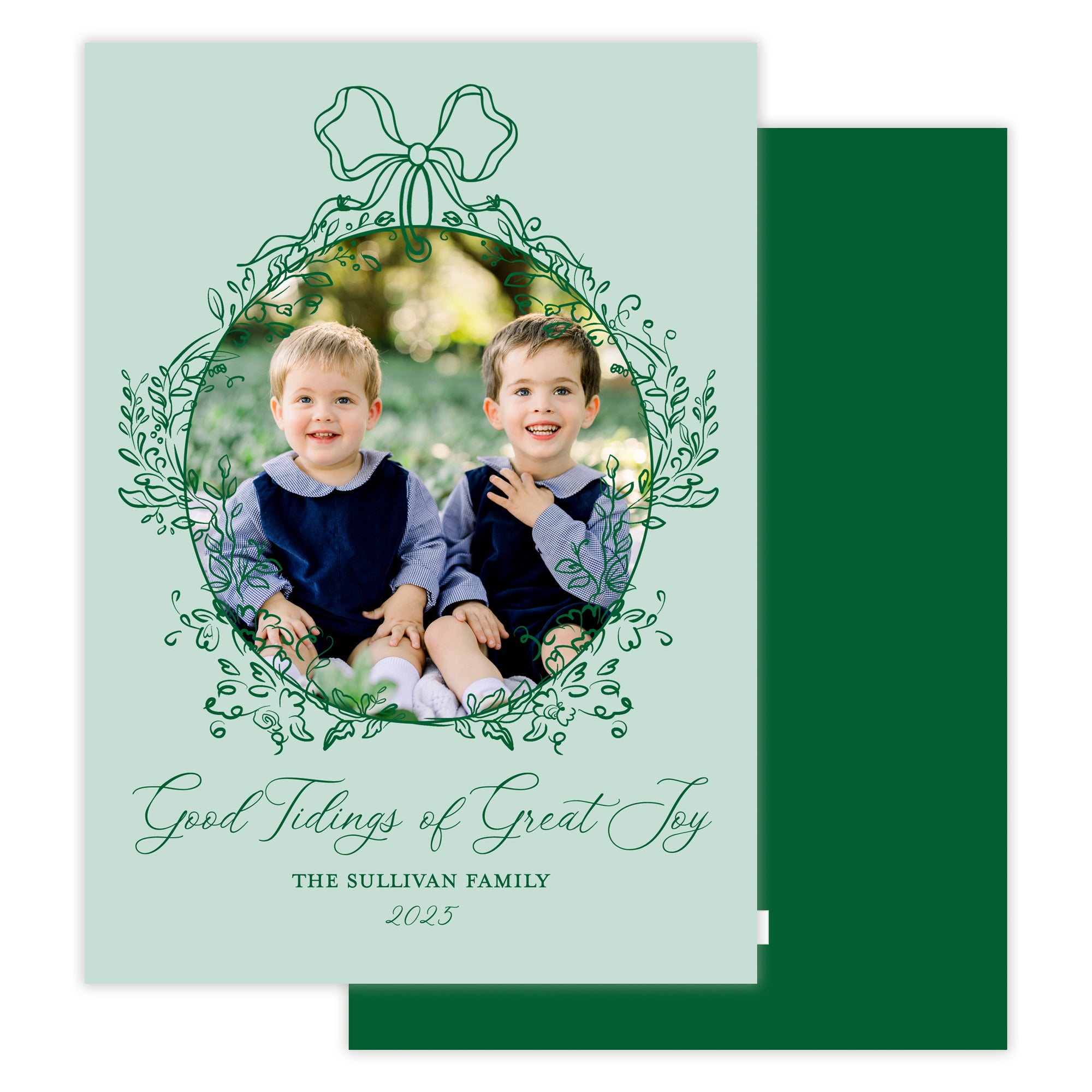 Holiday card with two children and decorative text and a bow floral frame on a light green background