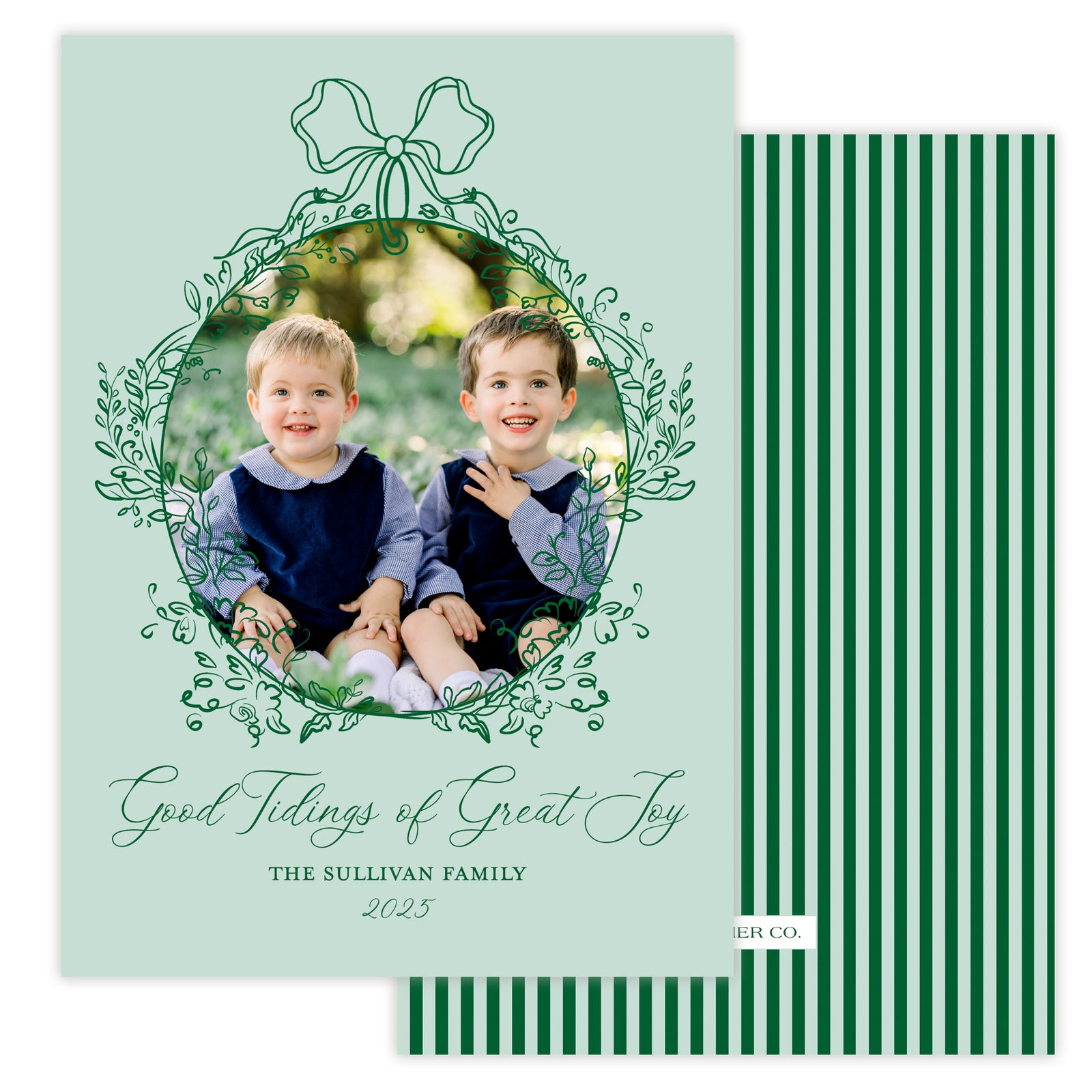 Holiday card with two children and decorative text and a bow floral frame on a light green background