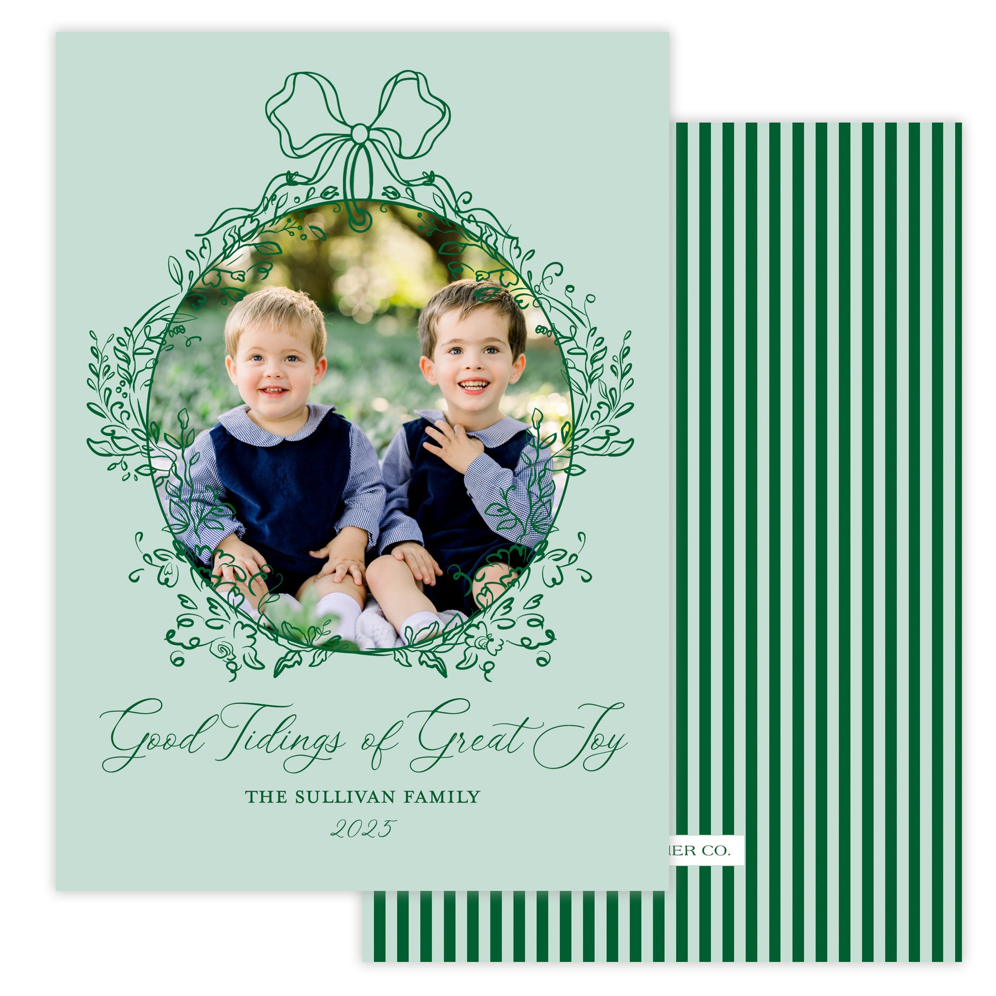 Holiday card with two children and decorative text and a bow floral frame on a light green background