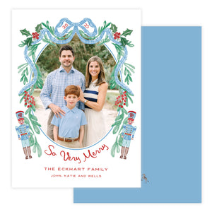 Christmas card with a family photo and toy solider and bow decoration.