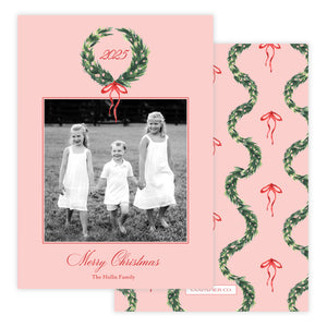 Christmas card with photo of three children and decorative wreath design on pink background